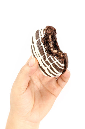 Image of chocolate cookie cake in human hand on white backgroundの写真素材