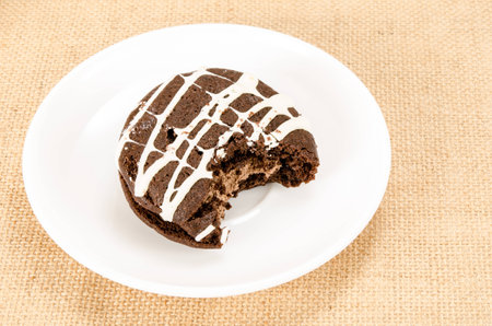 Image of chocolate cookie cake with a bite taken outの写真素材