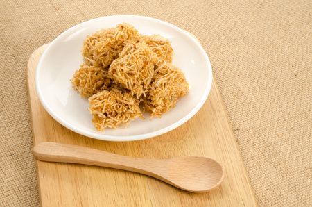 Sweet crispy noodle in ceramic dish on brown sack backgroundの写真素材