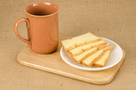 Image of slice crispy bread in ceramic dish on brown sack background
