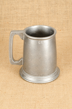 Image of old aluminium beer mug on white background brown sack backgroundの写真素材