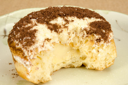 Image of donuts with bite taken out in ceramic dish on brown sack backgroundの写真素材