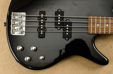 Part of electric bass guitar on brown sack background