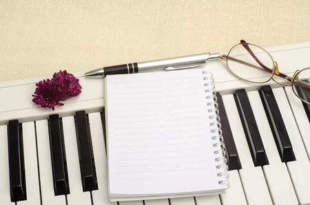 Part of keyboard with blank paper and penの写真素材