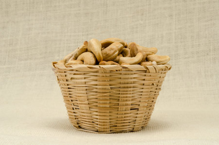 Cashew nuts in bamboo woven on sack backgroundの写真素材