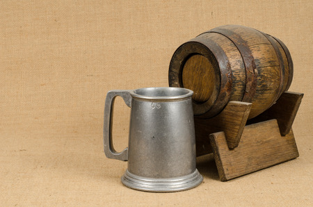 Old wooden barrel with aluminum beer mugの写真素材