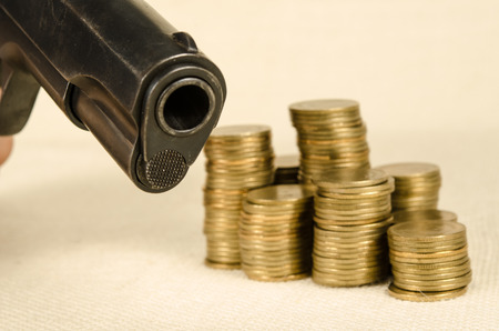 Gun and money on brown sack backgroundの写真素材