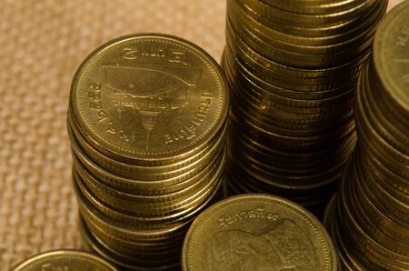 Stack of Thai gold coin on brown sack backgroundの写真素材