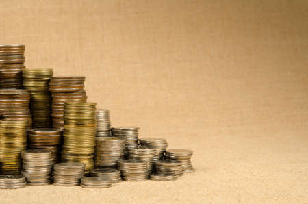Stack of coins on brown sack backgroundの写真素材