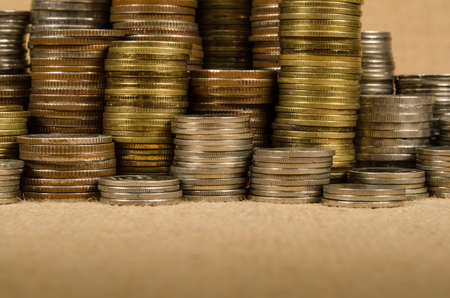Stack of coins on brown sack backgroundの写真素材
