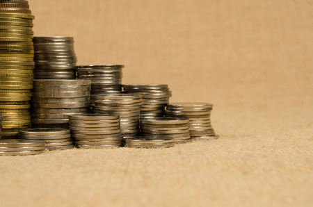 Stack of coins on brown sack backgroundの写真素材