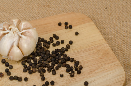 Black pepper with garlic on wooden cutting boardの写真素材
