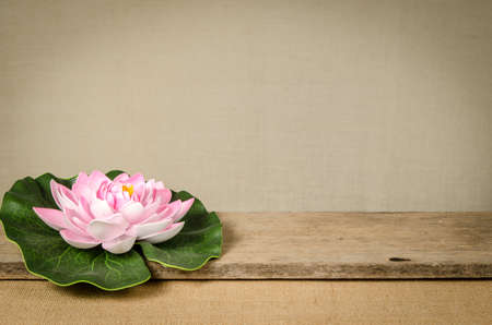 Artificial water lilly on old woodの写真素材