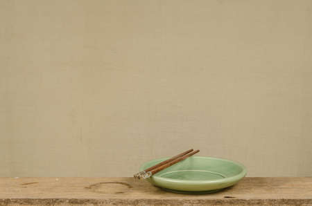 Green ceramic plate with wooden chop sticksの写真素材