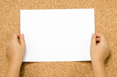 Cork textured with two hands and white blank paperの写真素材