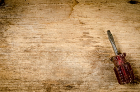 Old screw driver on wood board