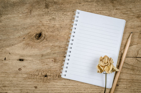 White blank notebook with pencil on old wood deskの写真素材