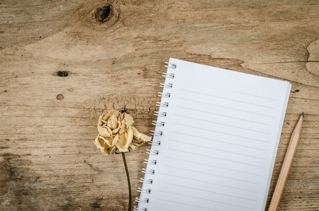 White blank notebook with pencil on old wood deskの写真素材