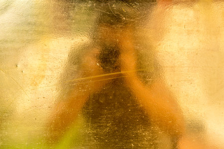 Brass or bronze plate with reflection of blurred camera manの写真素材
