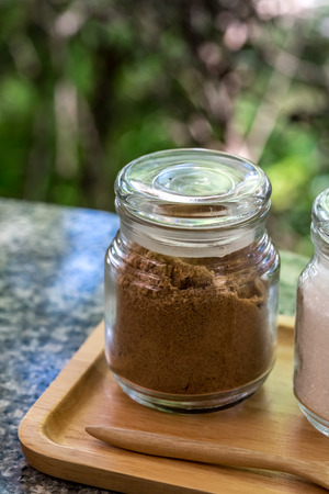 Brown sugar and white sugar in small glass bottleの写真素材