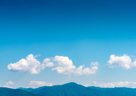 White cloud with blue sky with forest and mountainの写真素材