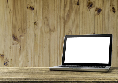Mock up Blank screen of Laptop on wooden office desk with wooden wall backgroundの写真素材