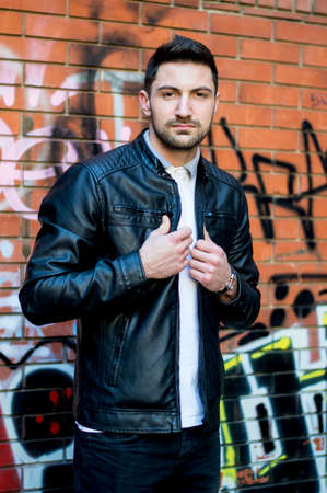 Handsome man in the urban environment fashionably dressed posing,standing,sitting and leaning.の写真素材
