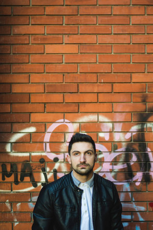 Handsome man in the urban environment fashionably dressed posing,standing,sitting and leaning.