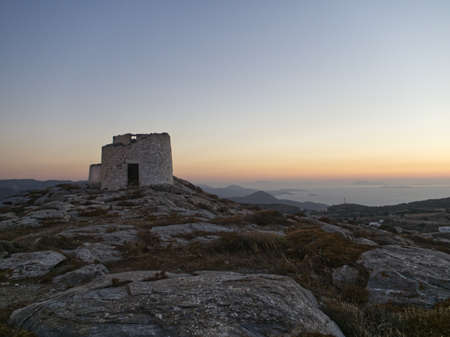 Windmill during sunset on a greek island in aegean seaの写真素材