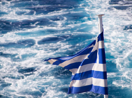 Greek flag on boat over wavesの写真素材