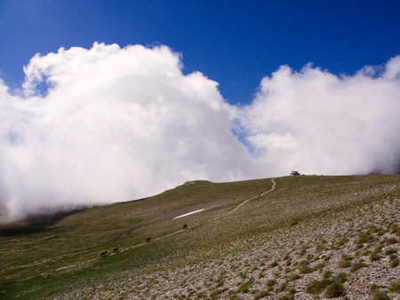 Footpath leading to mountain refugee camp. Sunny day with white clouds. Olympus, Greeceの写真素材