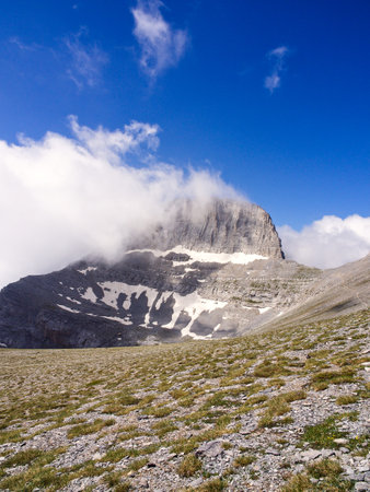 Mountain peak in blue sky and white clouds. Stefani peak also known as The Throne of Zeus, Olympus mountain, Greeceの写真素材
