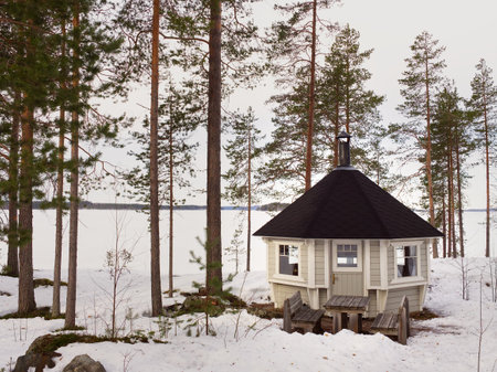 Cabin in the woods in snowy forest near a lake, Finlandの写真素材
