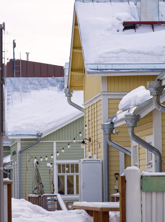 Yellow wooden house covered in snow in city neighborhood, Finlandの写真素材