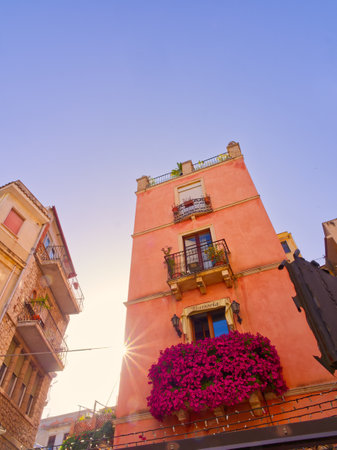 Taormina street building orange facade sun star, Sicily, Italyの写真素材