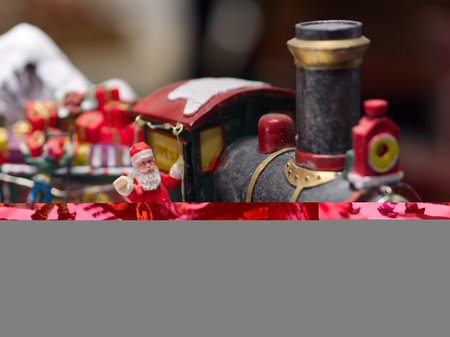 Miniature Christmas scene close-up with Santa Claus figurine waving from a little trainの写真素材