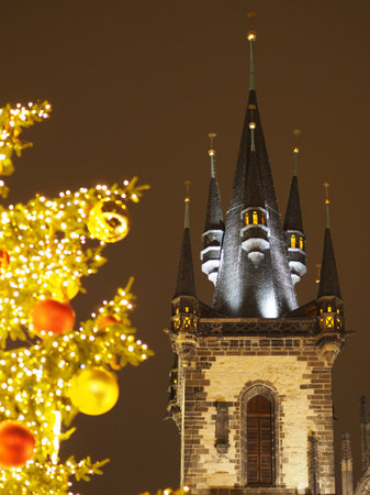 Gothic church tower lit at night with festive Christmas tree lights in foreground. Church of Our Lady, Pragueの写真素材