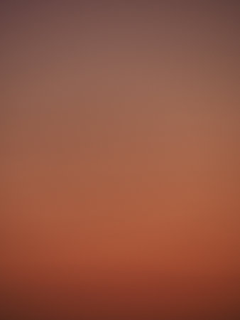 Smooth gradient of orange hue in a clear twilight skyの写真素材
