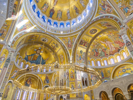 Lavish interior of a church with golden mosaics, domed ceiling, and religious iconography. Church of Saint Sava, Belgradeの写真素材