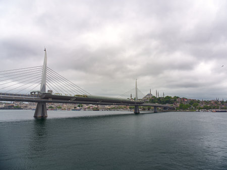 Modern cable-stayed bridge spans Bosphorus Strait in Istanbul, with city skyline and mosque in backgroundの写真素材