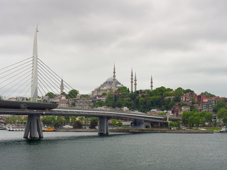 View of Istanbul with modern bridge, Blue Mosque, and Hagia Sophia against cloudy skyの写真素材