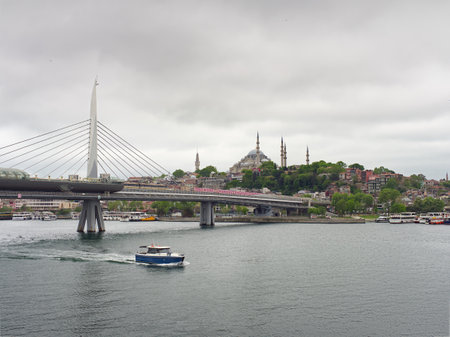 View of Istanbul skyline with modern bridge, Suleymaniye Mosque, and boats on the Golden Hornの写真素材
