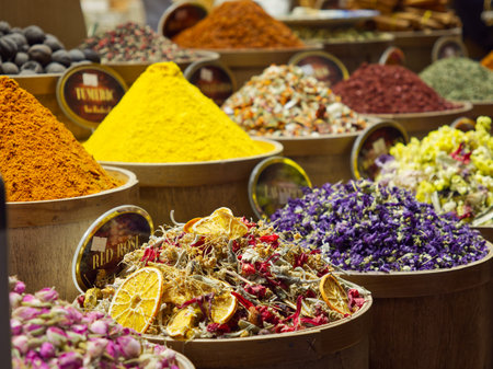 Vibrant array of spices, herbs, and dried flowers in bowls at a market or bazaarの写真素材