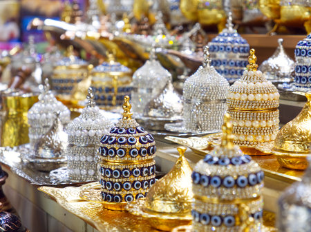 Luxurious display of gold, silver, and blue ornamental containers with intricate designs and jeweled detailsの写真素材
