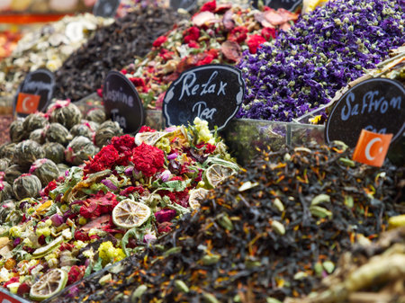 Assorted dried flowers, herbs, and teas in vibrant colors with handwritten labels at a market stallの写真素材