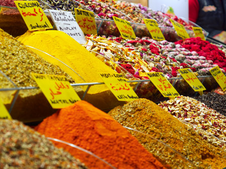 Vibrant array of spices and dried goods with price tags in a market stallの写真素材