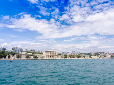 View of Dolmabahce Palace and Istanbul cityscape from turquoise waters of Bosphorus under blue skyの写真素材