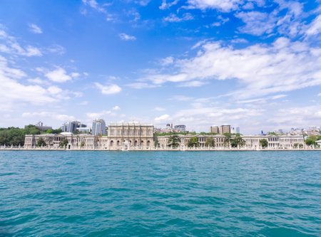 Panoramic view of Dolmabahce Palace along the Bosphorus strait in Istanbul, Turkey, under blue skyの写真素材