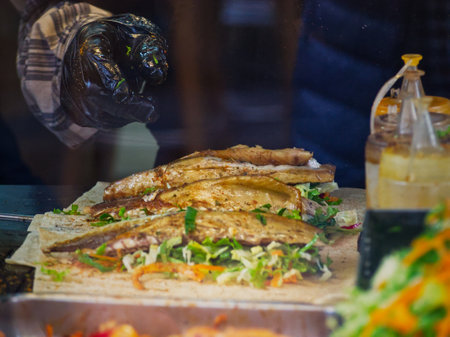 Close-up of a grilled sandwich with fresh salad on a wooden board, bottle in backgroundの写真素材
