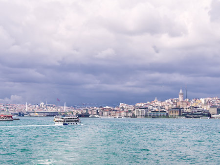 View of Istanbul cityscape with boats on the Bosphorus strait under cloudy skiesの写真素材